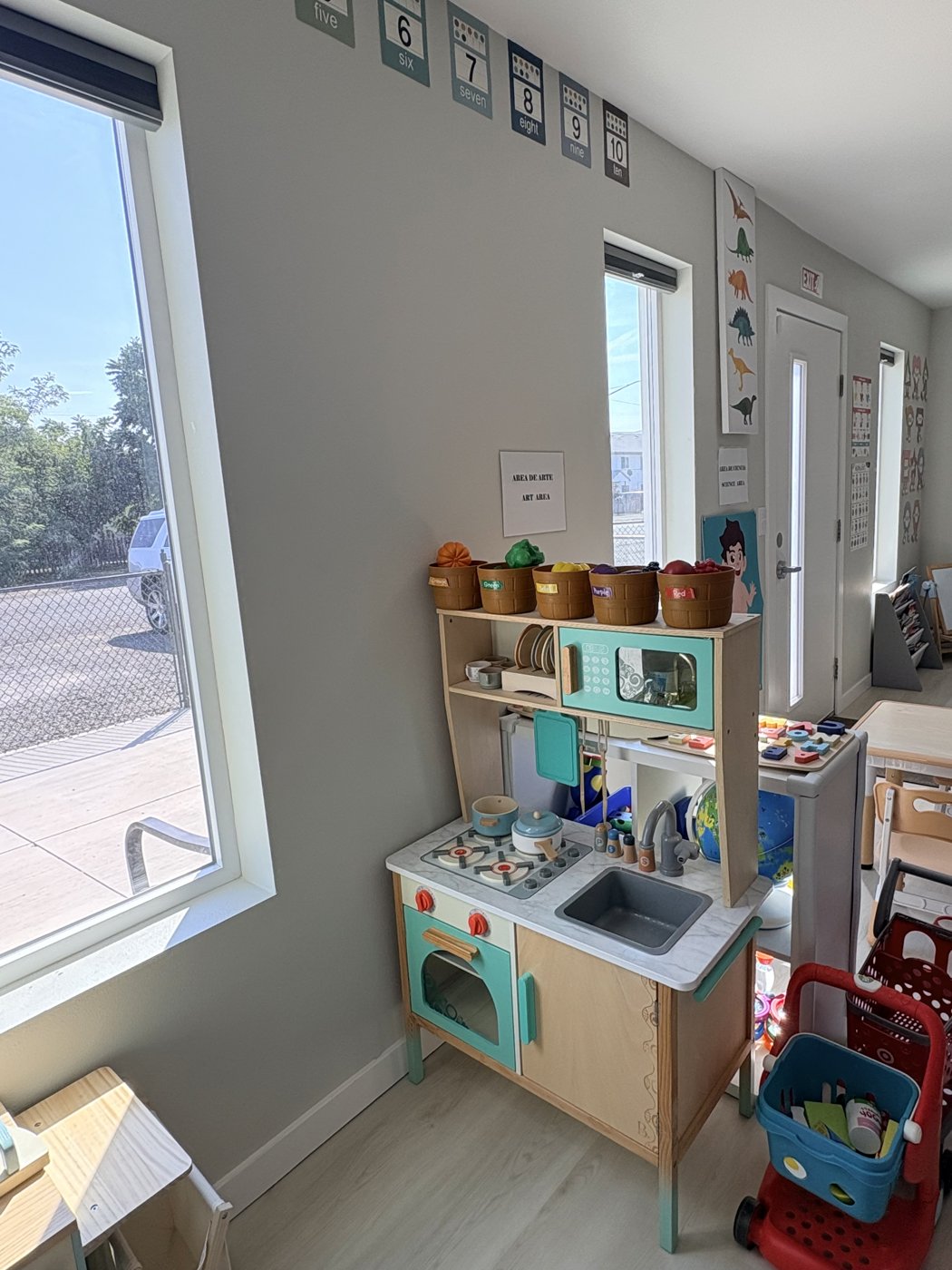 Art and science area with a wooden play kitchen, color sorting baskets and sunny windows